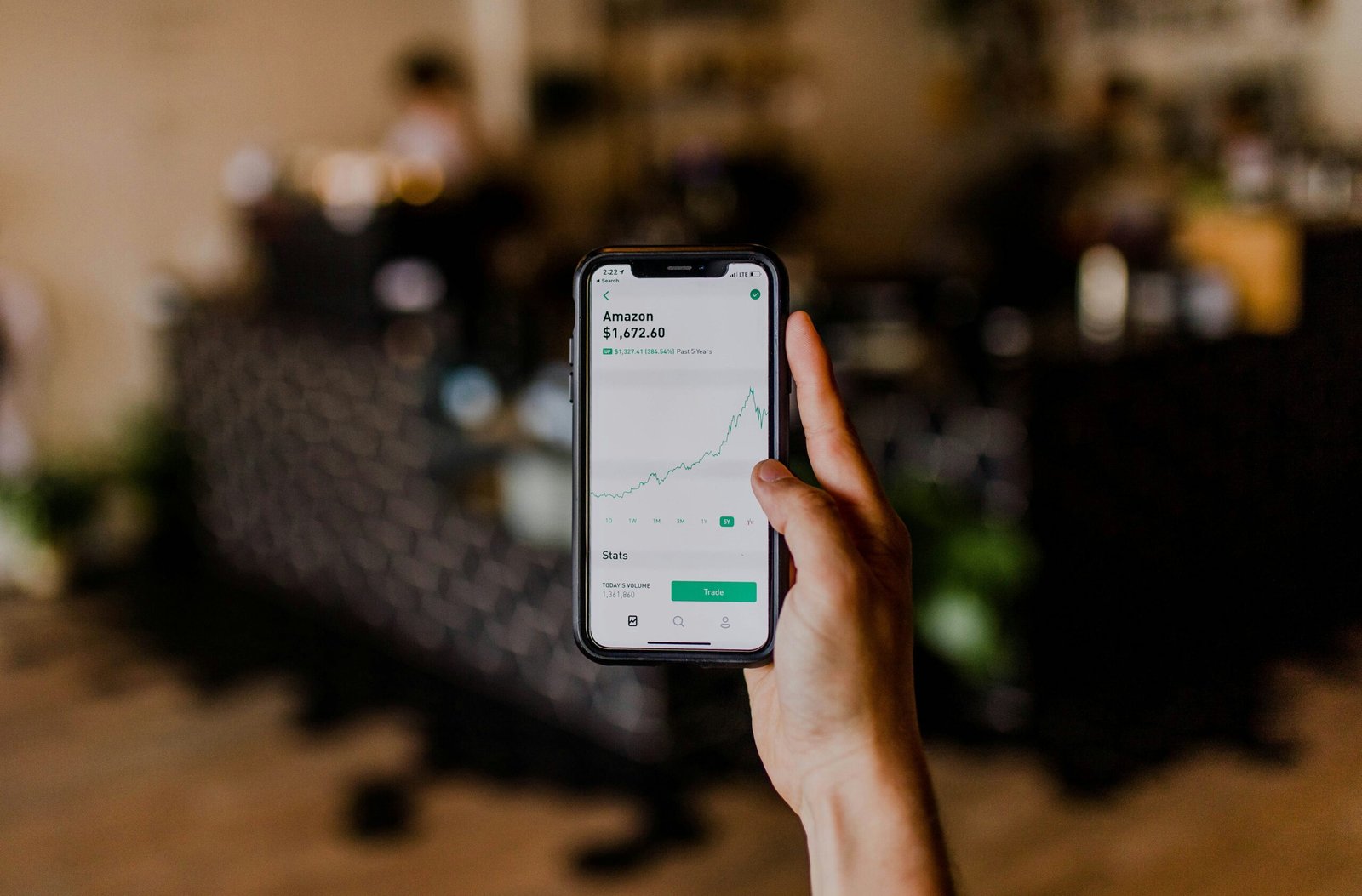 person holding black iPhone displaying stock exchange